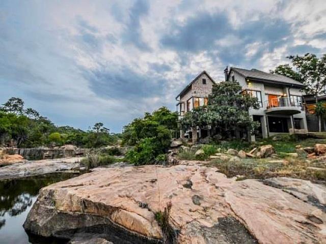 Modern glass bush house on the rocks